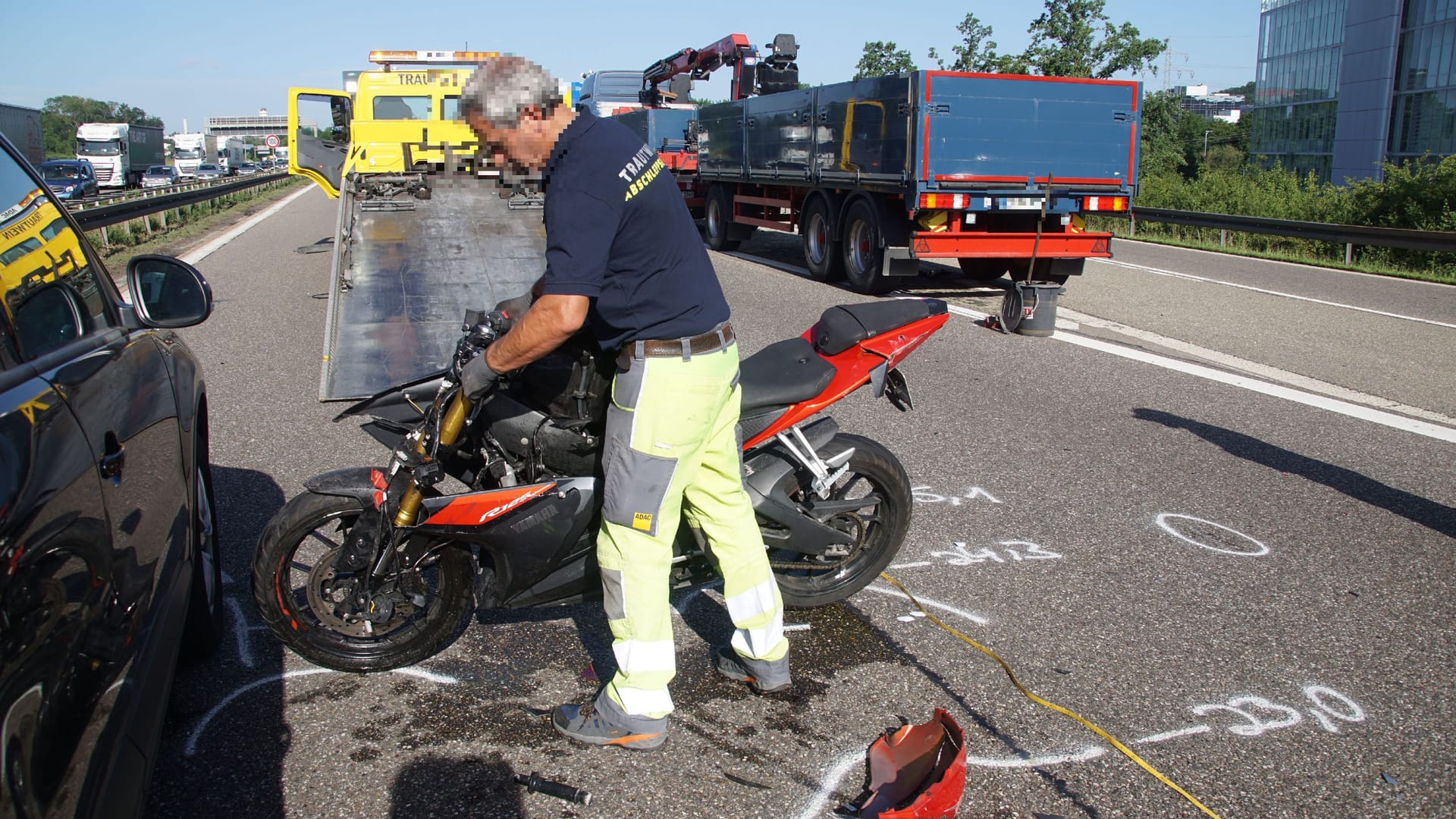 Aufräumarbeiten auf der Autobahn 81: Ein Helfer schiebt das Unfallmotorrad beiseite. Aufräumarbeiten auf der Autobahn 81: Ein Helfer schiebt das Unfallmotorrad beiseite.