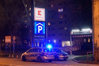 Zwei Einsatzwagen der Polizei parken vor einem Parkhaus (Symbolbild): Ein 17-Jähriger wurde in Bonn vergewaltigt.