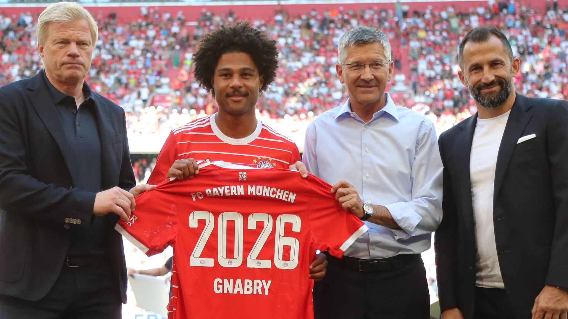 Serge Gnabry (2. v. li.) mit Bayern-Vorstandschef Kahn, Präsident Hainer und Sportvorstand Salihamidzic (v. li.): Der Nationalspieler bleibt bis 2026 in München.