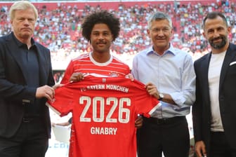 Serge Gnabry (2. v. li.) mit Bayern-Vorstandschef Kahn, Präsident Hainer und Sportvorstand Salihamidzic (v. li.): Der Nationalspieler bleibt bis 2026 in München.