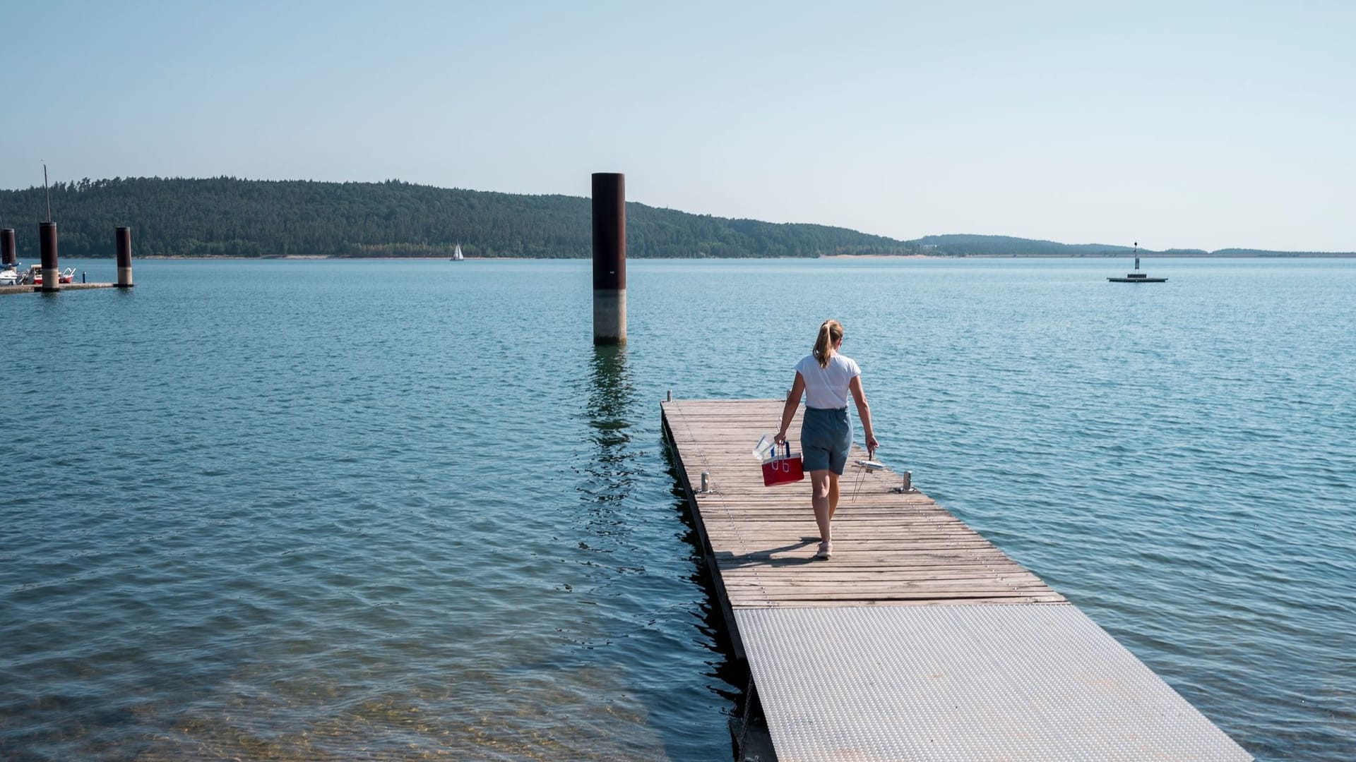 Julia Wittmann geht über einen Steg (Symbolbild): Die Hygienekontrolleurin entnimmt im mittelfränkischen Brombachsee eine Wasserprobe. Julia Wittmann geht über einen Steg (Symbolbild): Die Hygienekontrolleurin entnimmt im mittelfränkischen Brombachsee eine Wasserprobe.