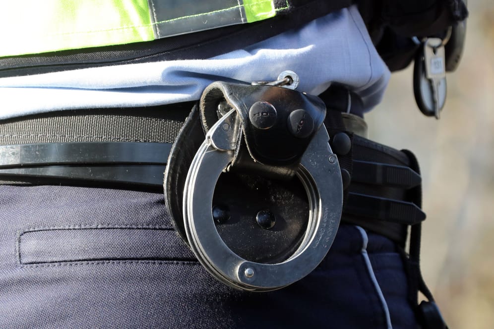 Handschellen am Gürtel eines Polizisten (Symbolbild): Die Beamten nahmen den betrunkenen Mann vorläufig fest.