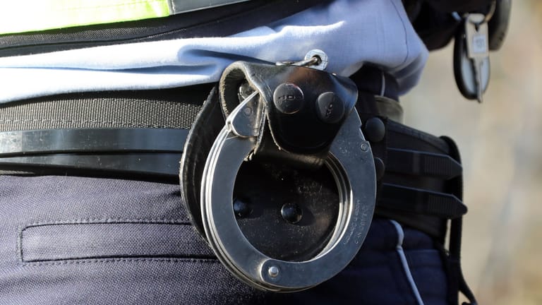 Handschellen am Gürtel eines Polizisten (Symbolbild): Die Beamten nahmen den betrunkenen Mann vorläufig fest.