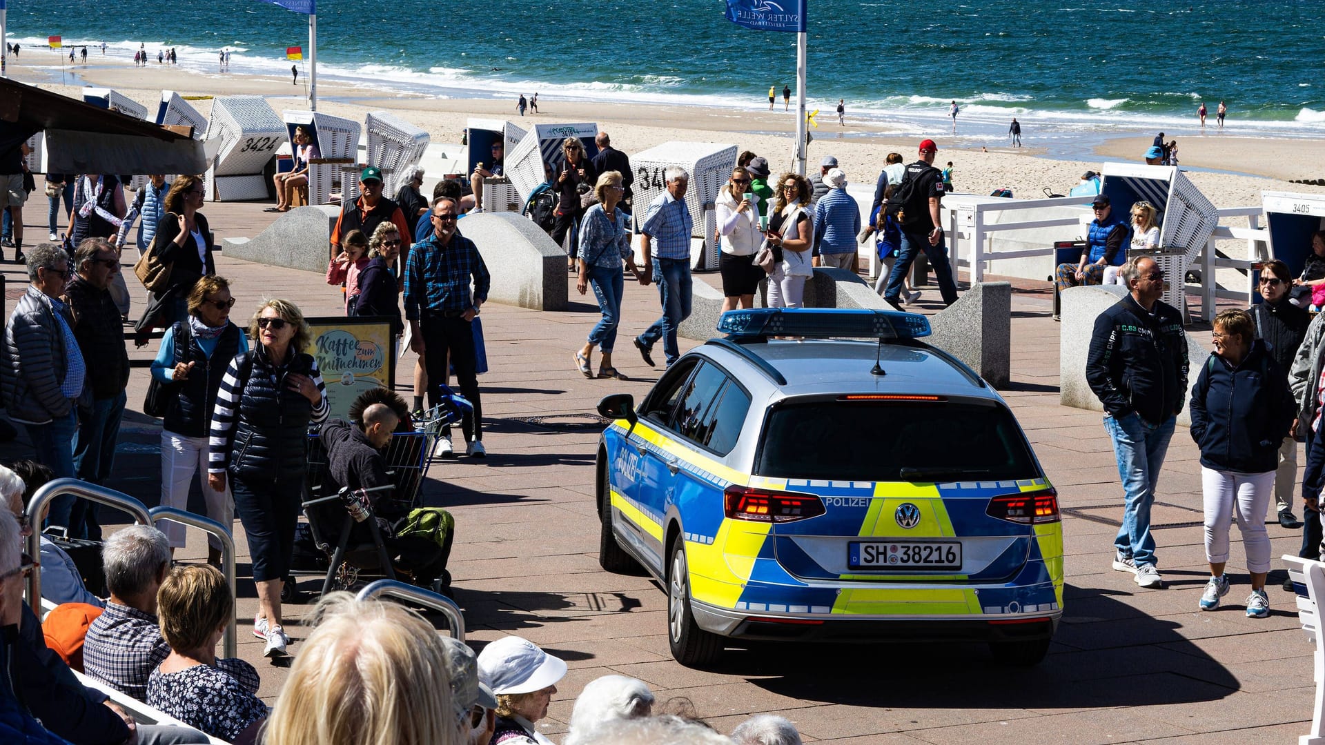 Ein Polizeiauto fährt an der Strandpromenade in Westerland entlang: Die Gemeinde Sylt hat nun schärfere Kontrollen angekündigt.