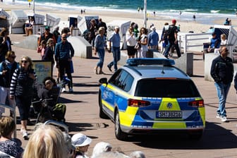 Ein Polizeiauto fährt an der Strandpromenade in Westerland entlang: Die Gemeinde Sylt hat nun schärfere Kontrollen angekündigt.
