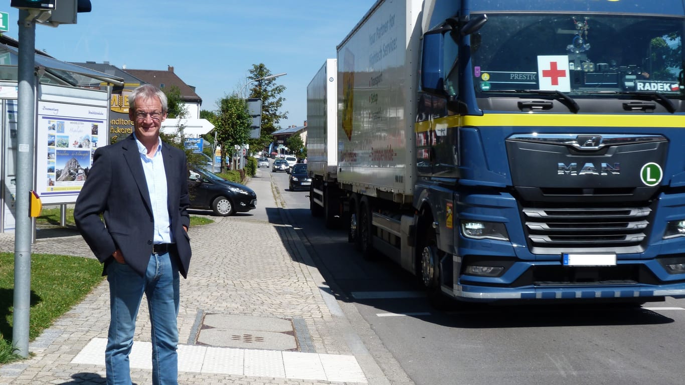 Brannenburgs Bürgermeister Matthias Jokisch neben einem vorbeifahrenden LKW: Wenn Blockabfertigung ist, quält sich auch der Schwerlastverkehr durch die Dörfer.