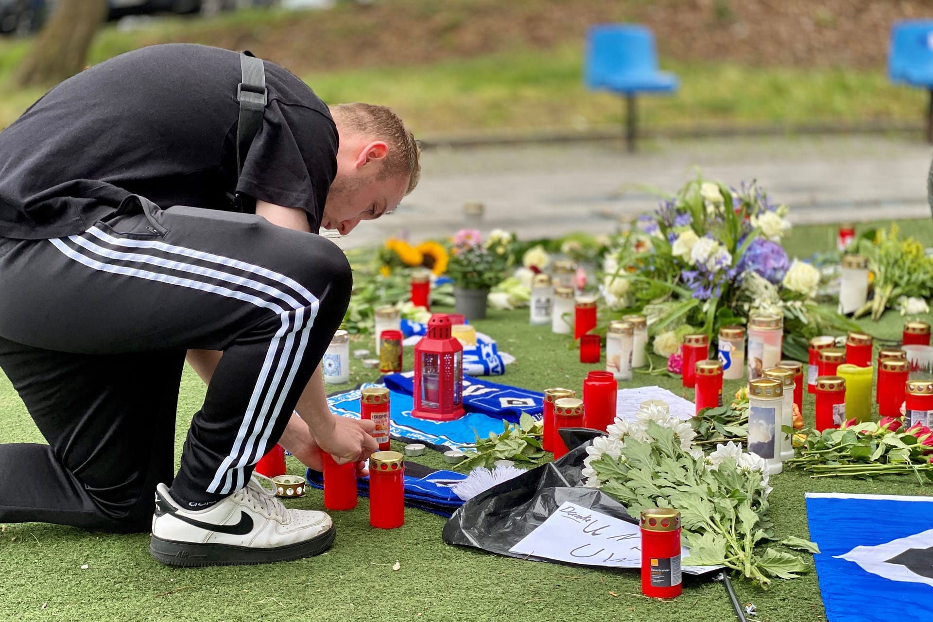 HSV-Fan Leon-Pascal zündet eine Kerze am Uwe-Seelers-Fuß vor dem Hamburger Volksparkstadion an: Am Sonntag steht das erste Heimspiel der Saison gegen Hansa Rostock an.