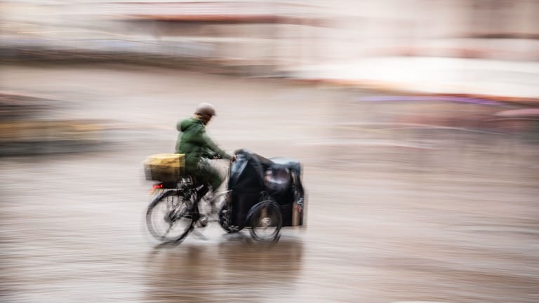 Ein Mann fährt an einem regnerischen und windigen Sonntag über den Römerberg (Symbolbild). In Niedersachsen fällt die Förderung von Lastenrädern zukünftig weg.