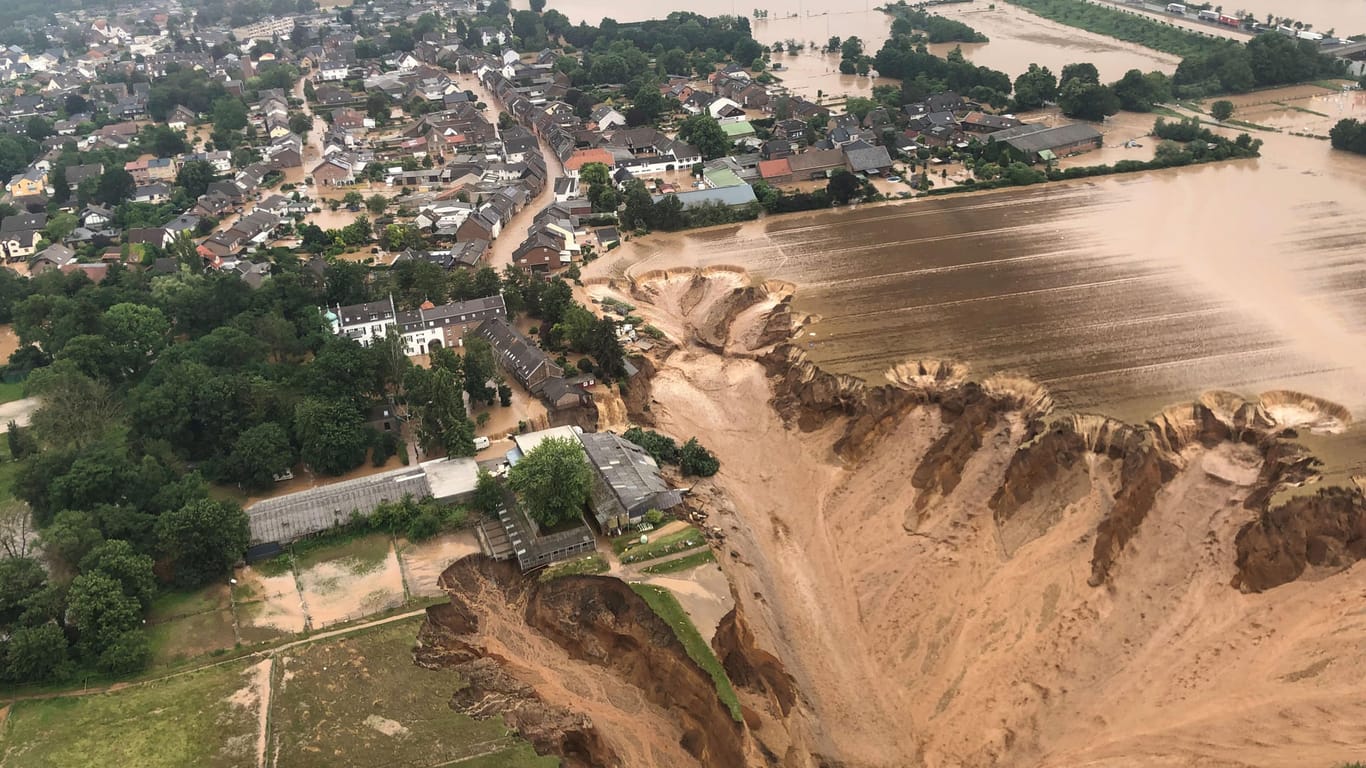 Ein Luftbild zeigt einen gewaltigen Erdrutsch in Erftstadt-Blessem an einem Tagebau: Gegen die Eigentümer und Verpächter der Kiesgrube wird ermittelt.