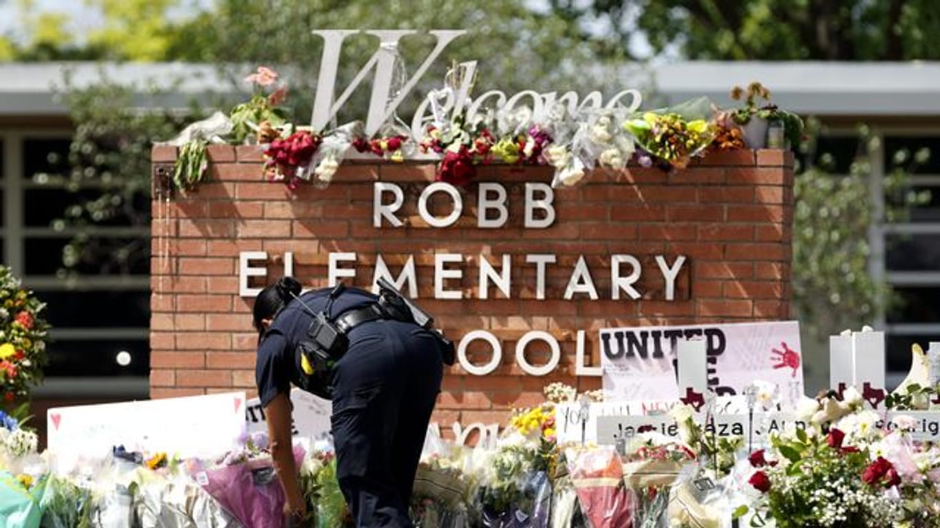 Ein Polizeibeamter legt Blumen vor der Robb Elementary School nieder.