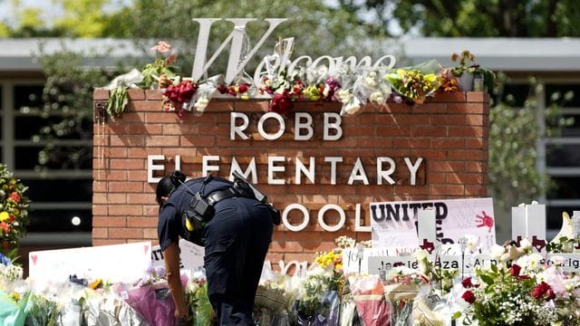 Ein Polizeibeamter legt Blumen vor der Robb Elementary School nieder.