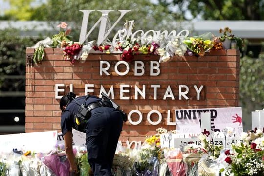 Ein Polizeibeamter legt Blumen vor der Robb Elementary School nieder.