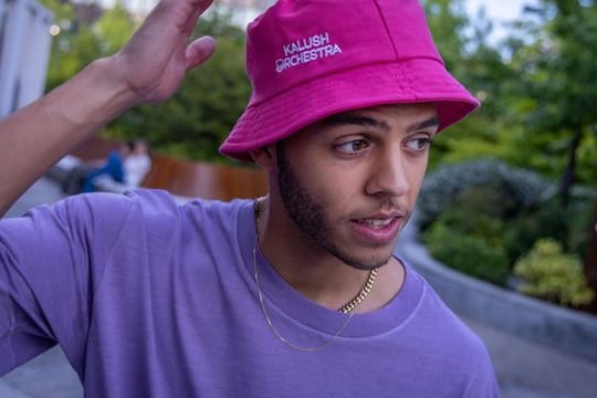 Sänger Malik Harris mit einem Fischerhut, Bucket Hat (Eimer-Hut) genannt.