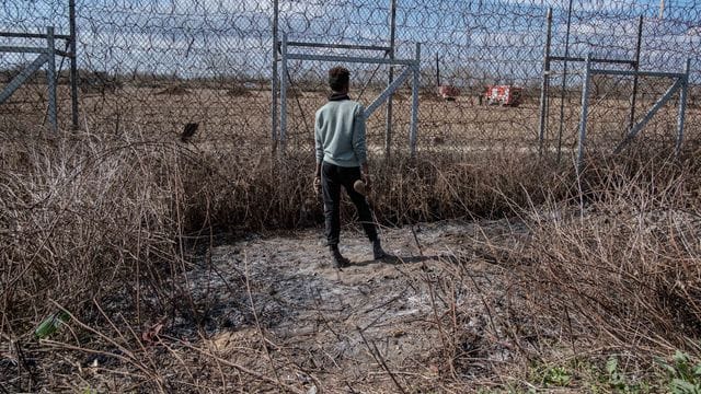 Ein Migrant am Grenzzaun an der türkisch-griechischen Grenze in Pazarkule.