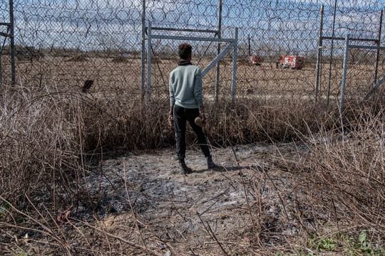 Ein Migrant am Grenzzaun an der türkisch-griechischen Grenze in Pazarkule.