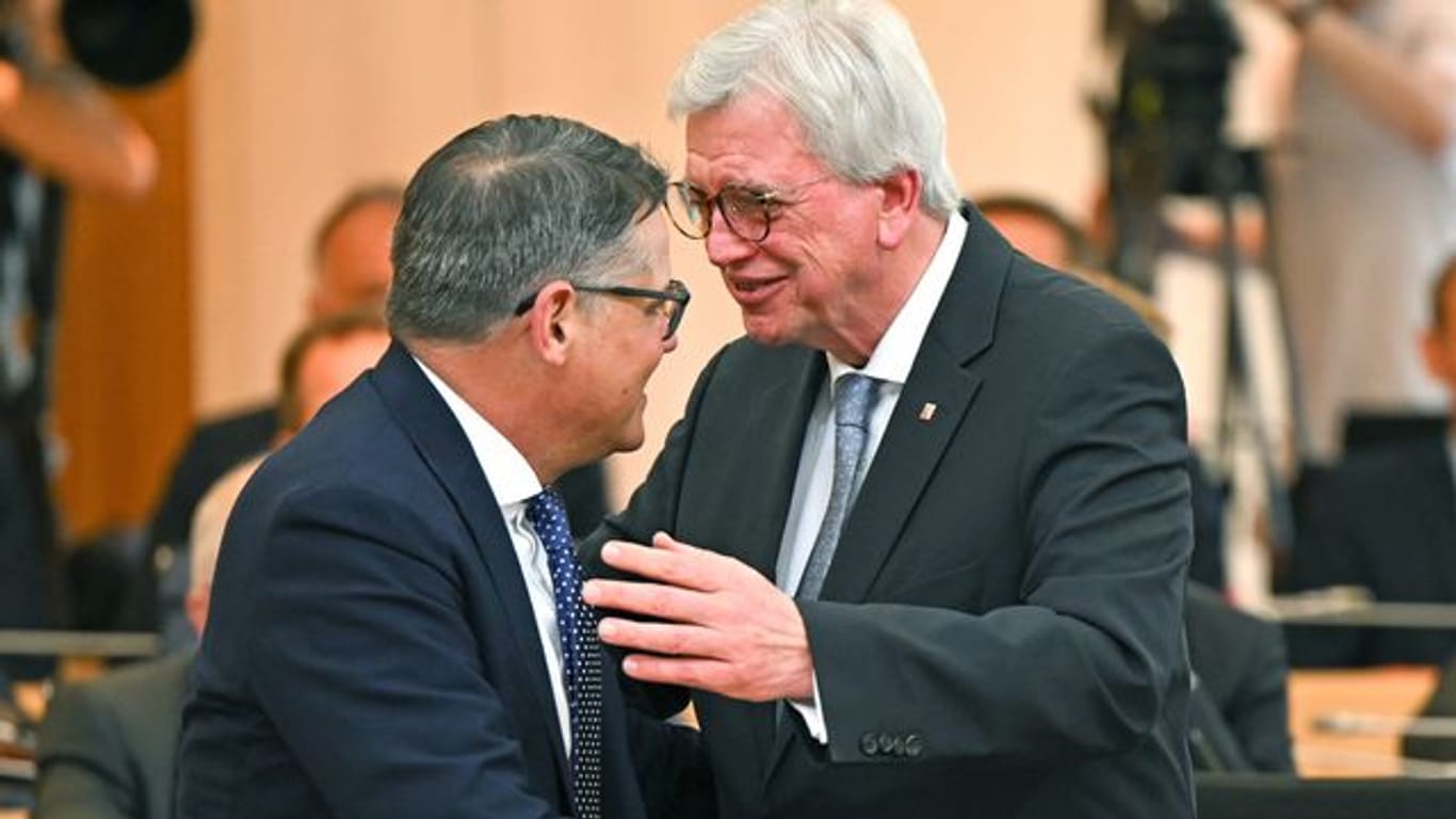 Neuer und alter Regierungschef: Boris Rhein (l) nimmt im Plenarsaal des hessischen Landtags die Glückwünsche seines Amtsvorgängers Volker Bouffier entgegen.