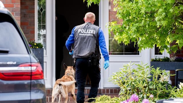 Ein Diensthundeführer der Polizei geht mit einem Spürhund zu einem Wohnhaus in Wiesmoor. Ein Diensthundeführer der Polizei geht mit einem Spürhund zu einem Wohnhaus in Wiesmoor.