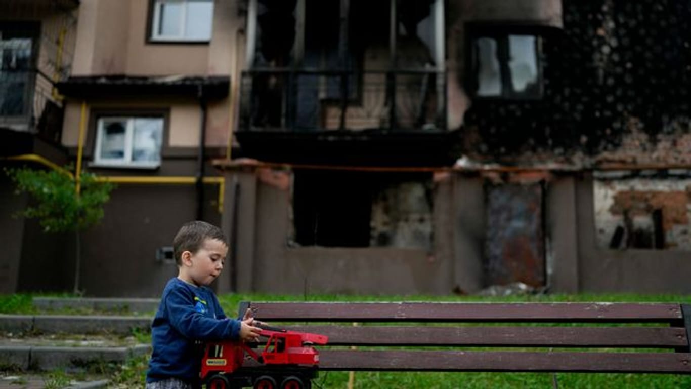 Vor einem zerstörten Gebäude in Irpin nahe Kiew spielt der kleine Yarik mit seinem Spielzeug-Lastwagen.