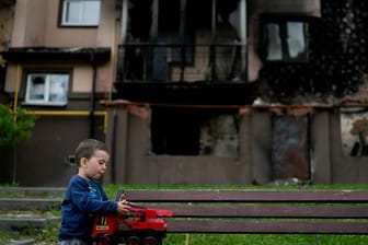 Vor einem zerstörten Gebäude in Irpin nahe Kiew spielt der kleine Yarik mit seinem Spielzeug-Lastwagen.