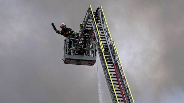 Ein Feuerwehrmann in einem Korb einer Drehleiter während eines Einsatzes (Archivbild). Ein Feuerwehrmann in einem Korb einer Drehleiter während eines Einsatzes (Archivbild).