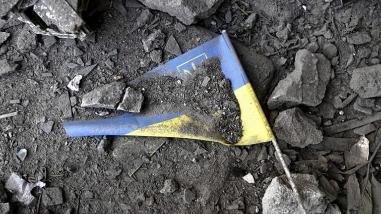 Eine ukrainische Flagge liegt nach einem Raketeneinschlag in Charkiw in den Trümmern.