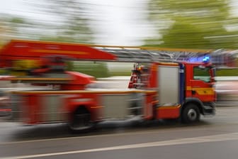 Ein Feuerwehrfahrzeug mit Drehleiter fährt zu einem Einsatz (Symbolfoto).