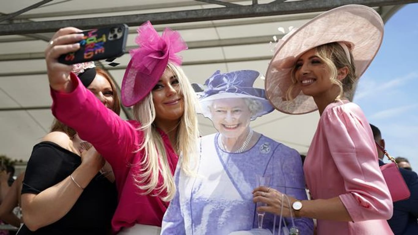 Fast wie in echt: Besucherinnen des Cazoo Derby in Surrey posieren für ein Selfie mit einem Pappausschnitt der Queen.