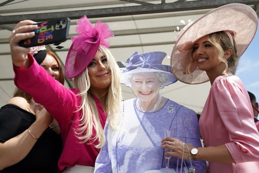 Fast wie in echt: Besucherinnen des Cazoo Derby in Surrey posieren für ein Selfie mit einem Pappausschnitt der Queen.