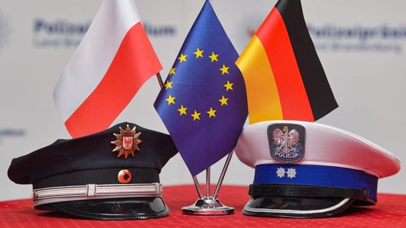 Fähnchen von Polen, der EU und Deutschland (l-r).