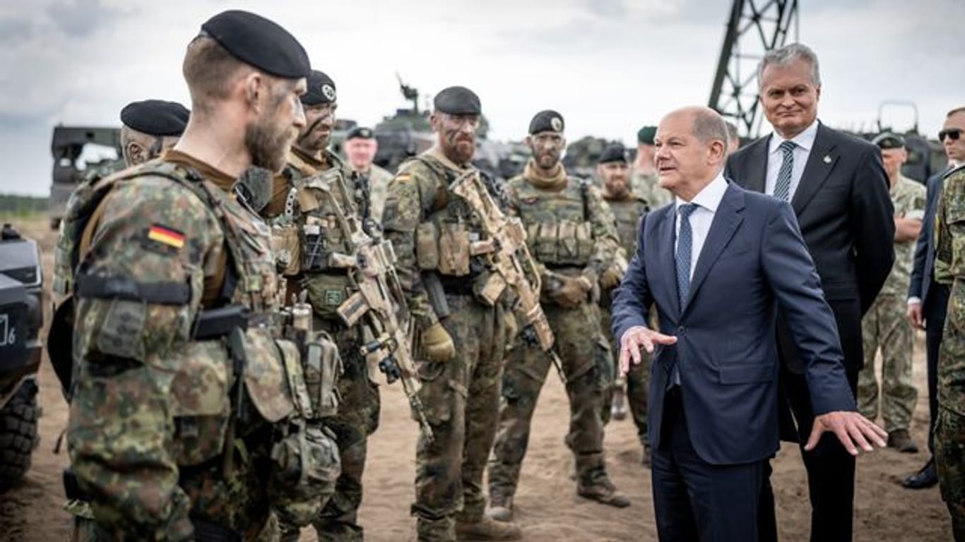 Bundeskanzler Olaf Scholz (M, SPD) besucht die NATO Enhanced Forward Presence Battle Group (eFP-Bataillon) im Camp Adrian Rohn.
