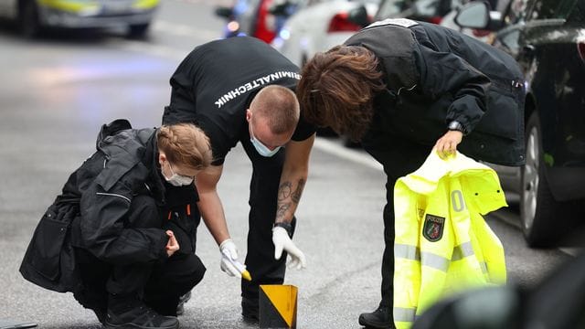 Kriminaltechniker untersuchen einen Tatort, an dem die Polizei einen bewaffneten Mann angeschossen hat.