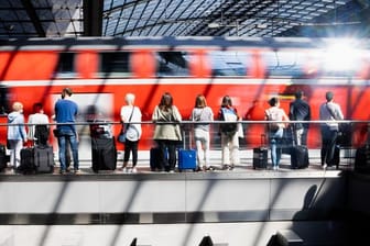 Fahrgäste warten am Berliner Hauptbahnhof auf die Einfahrt eines Regionalexpresses.