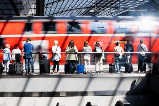 Fahrgäste warten am Berliner Hauptbahnhof auf die Einfahrt eines Regionalexpresses.