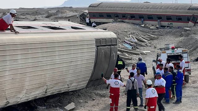 Rettungskräfte im Einsatz an dem entgleisten Zug im Iran nahe der Stadt Tabas. Rettungskräfte im Einsatz an dem entgleisten Zug im Iran nahe der Stadt Tabas.