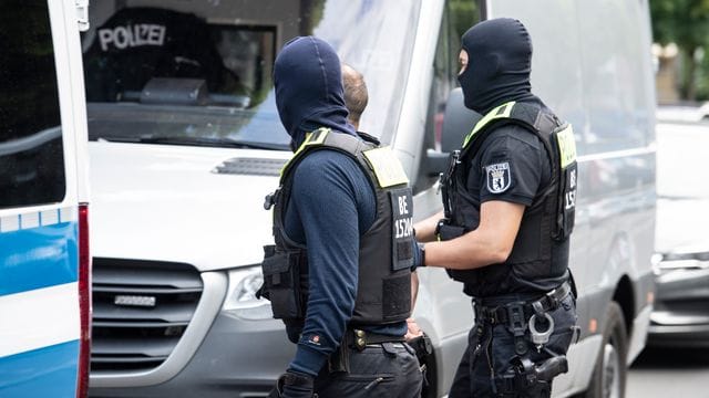 Polizisten führen einen Mann ab. Polizisten führen einen Mann ab.
