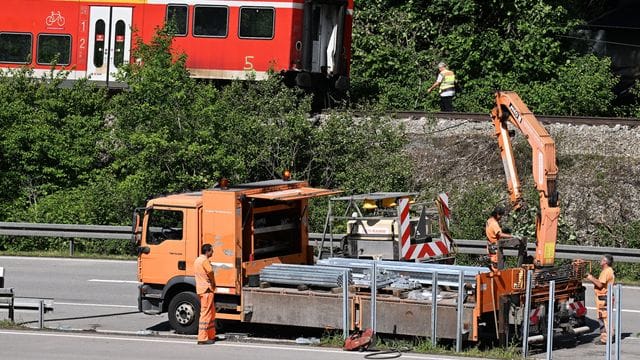 Arbeiter bereiten die Bundesstraße B2 neben der Zugunglücksstelle wieder für den Verkehr vor. Arbeiter bereiten die Bundesstraße B2 neben der Zugunglücksstelle wieder für den Verkehr vor.