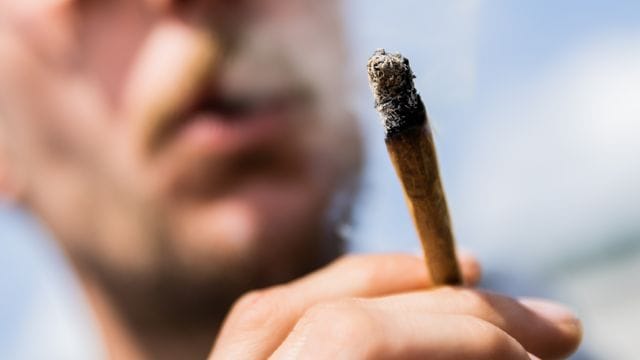 Ein Mann raucht während einer Demonstrationen für eine zügige Legalisierung von Cannabis einen Joint mit Medizinalcannabis. Ein Mann raucht während einer Demonstrationen für eine zügige Legalisierung von Cannabis einen Joint mit Medizinalcannabis.