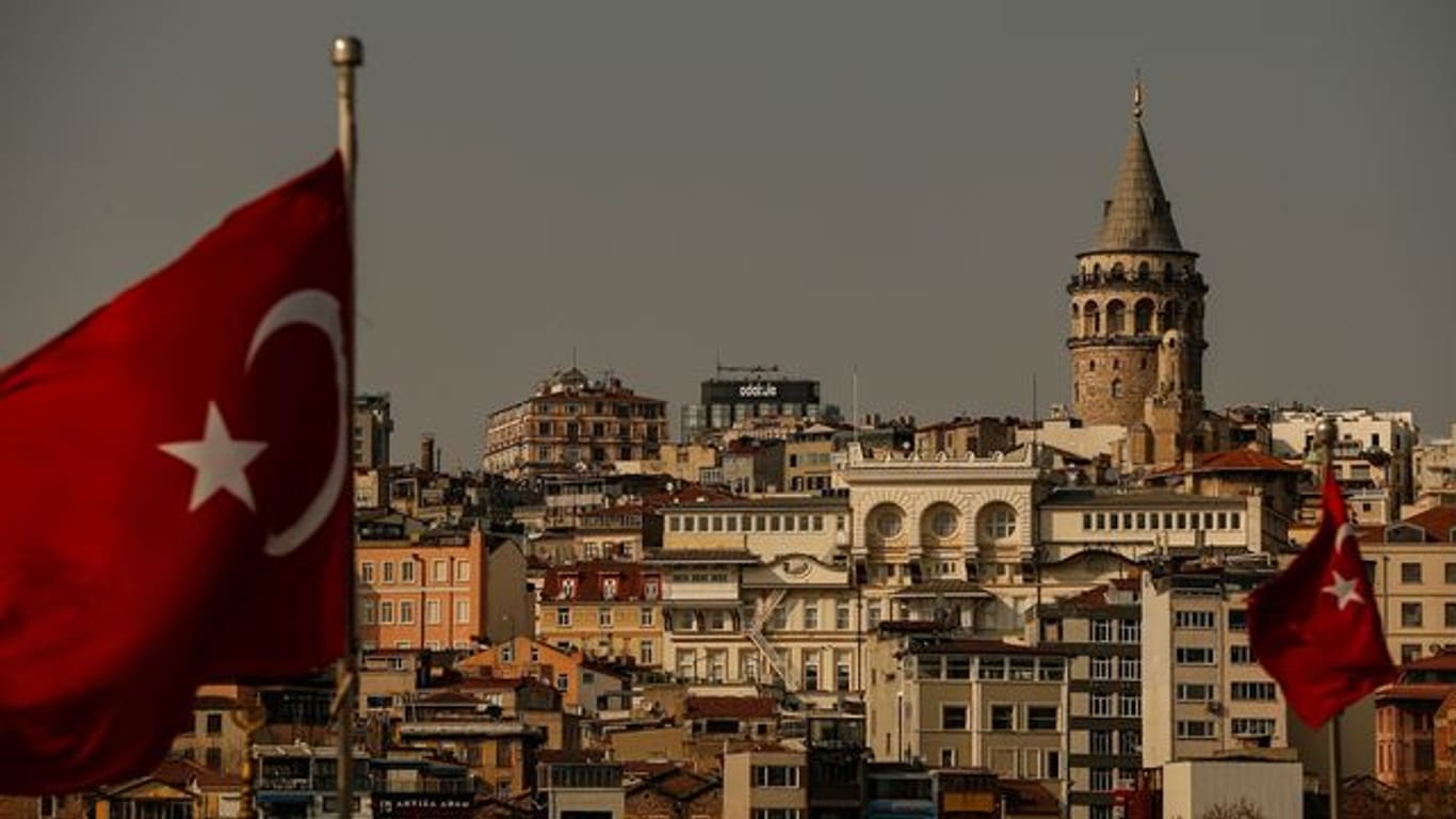 Zwei türkische Flaggen wehen vor der Kulisse des Galataturms in Istanbul.