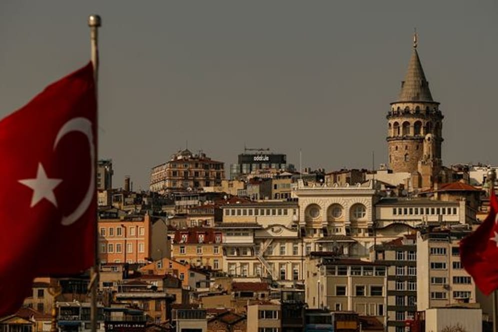 Zwei türkische Flaggen wehen vor der Kulisse des Galataturms in Istanbul.