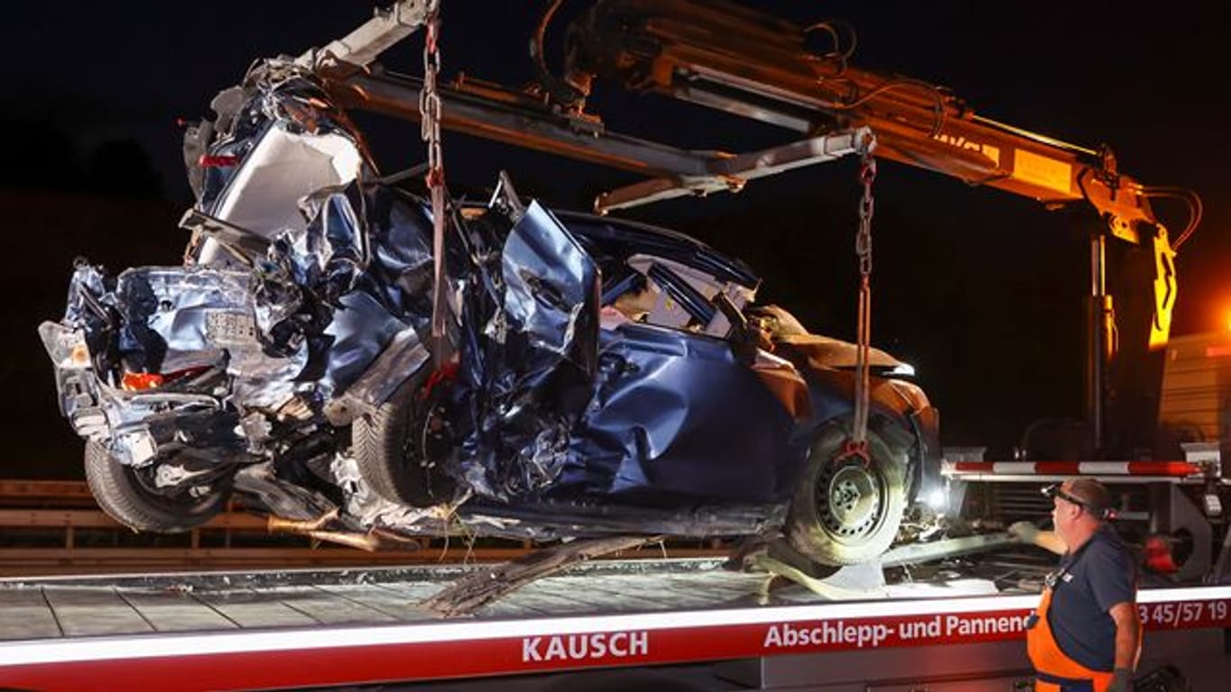 Ein Mitarbeiter eines Abschleppunternehmens verlädt das Wrack eines Pkw nach dem schweren Verkehrsunfall auf der A14 bei Halle-Trotha.