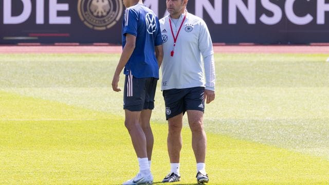 Bundestrainer Hansi Flick (r) spricht im Training mit Jamal Musiala.