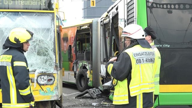 Einsatzkräfte stehen vor dem beschädigten Bus und der ebenfalls beschädigten Straßenbahn. Einsatzkräfte stehen vor dem beschädigten Bus und der ebenfalls beschädigten Straßenbahn.