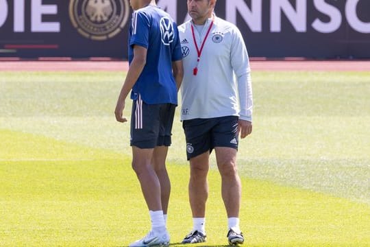 Bundestrainer Hansi Flick (r) spricht während des Trainings der deutschen Nationalmannschaft mit Jamal Musiala.