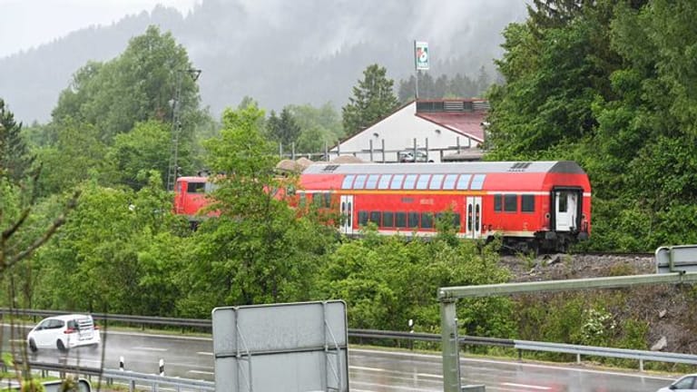 Die Lok und ein Wagon des verunglückten Zugs stehen an der Unglücksstelle auf dem Gleis.