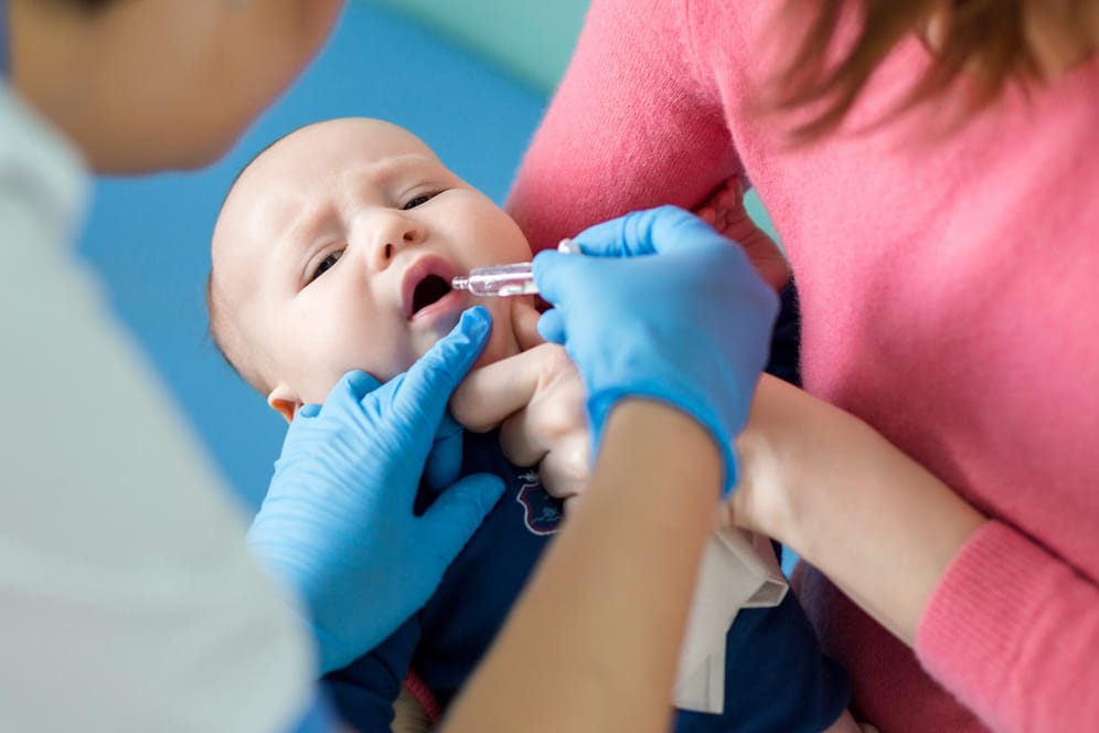 Ein Säugling erhält eine Schluckimpfung.