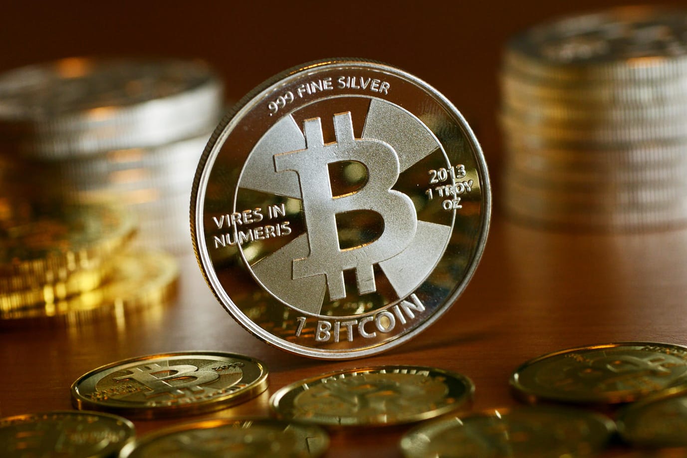Münzen mit dem Aufdruck "Bitcoin" stehen auf einem Tisch (Symbolbild): Drei Jahre nach einem schweren Hackerangriff bekommt die Uni Maastricht erheblich mehr Geld zurück, als sie den Kriminellen gezahlt hatte.