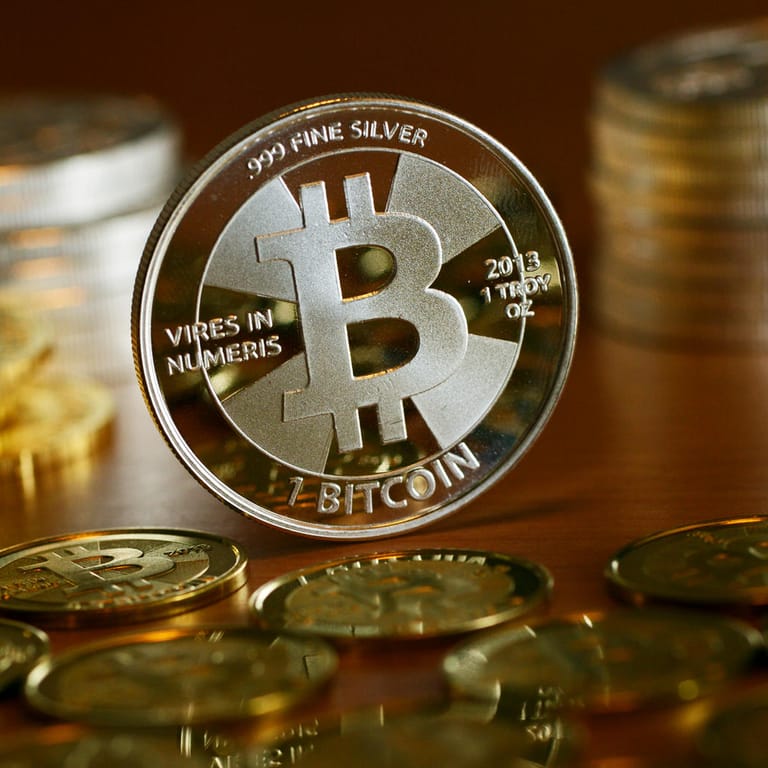 Münzen mit dem Aufdruck "Bitcoin" stehen auf einem Tisch (Symbolbild): Drei Jahre nach einem schweren Hackerangriff bekommt die Uni Maastricht erheblich mehr Geld zurück, als sie den Kriminellen gezahlt hatte.