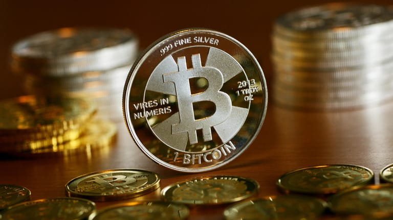 Münzen mit dem Aufdruck "Bitcoin" stehen auf einem Tisch (Symbolbild): Drei Jahre nach einem schweren Hackerangriff bekommt die Uni Maastricht erheblich mehr Geld zurück, als sie den Kriminellen gezahlt hatte.
