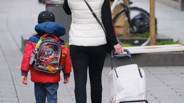 Mutter spaziert mit ihrem Kind (Archiv): Bund und Länder hatten im vergangenen September einen Rechtsanspruch auf Ganztagsbetreuung in der Grundschule beschlossen.