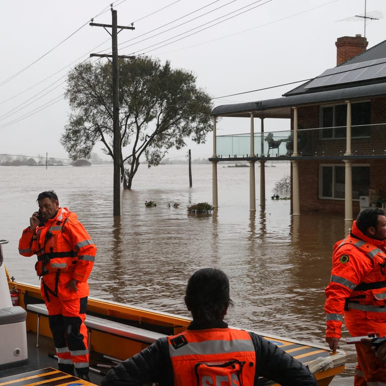 Rettungskräfte in den Fluten: Im Großraum der Millionenstadt mit dem weltberühmten Opernhaus wurden ganze Gebiete meterhoch überflutet.